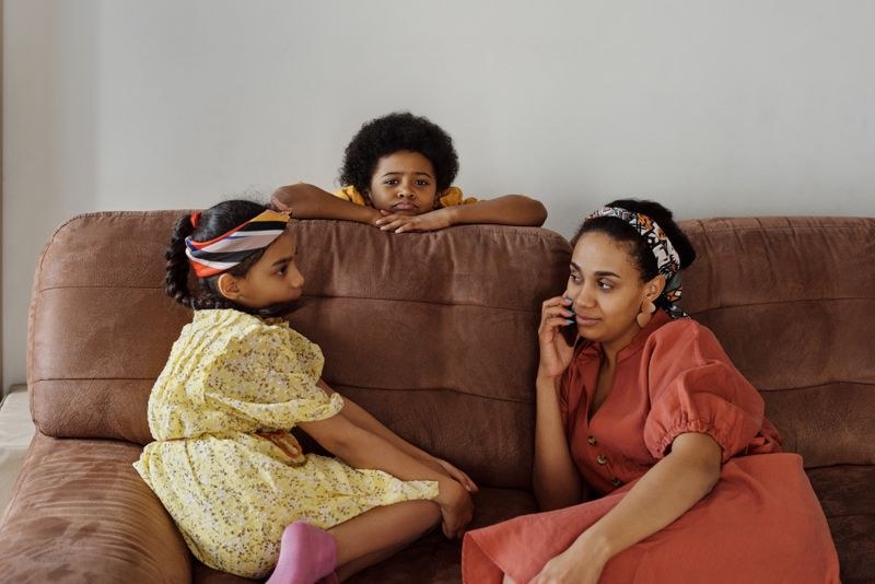 A mother spending time with her children on the sofa at home