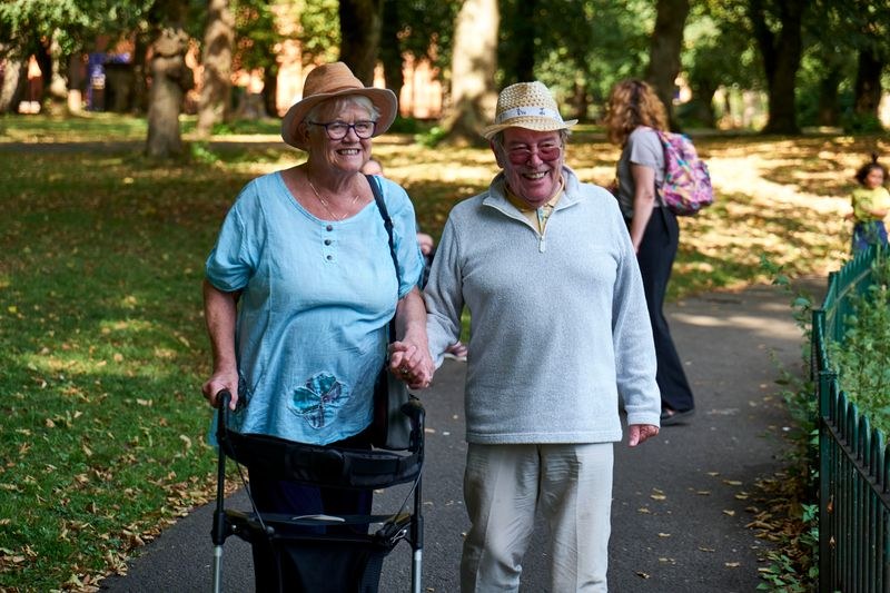 An older couple enjoying a walk together in a sunny park